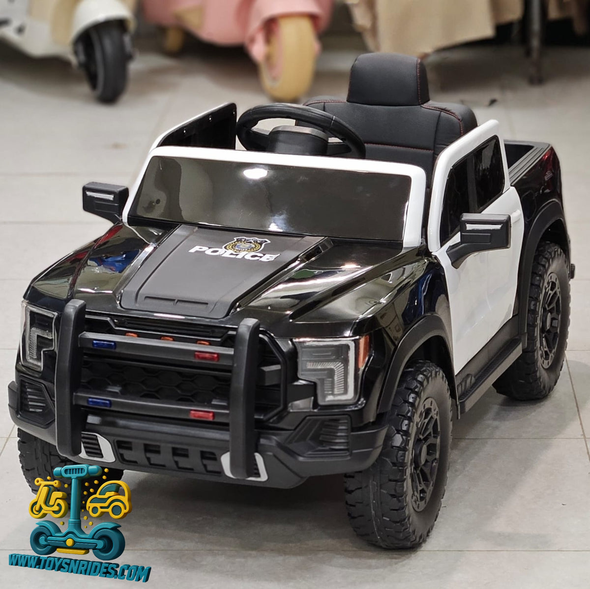 Black and white toy police car with detailed features on a gray floor.
