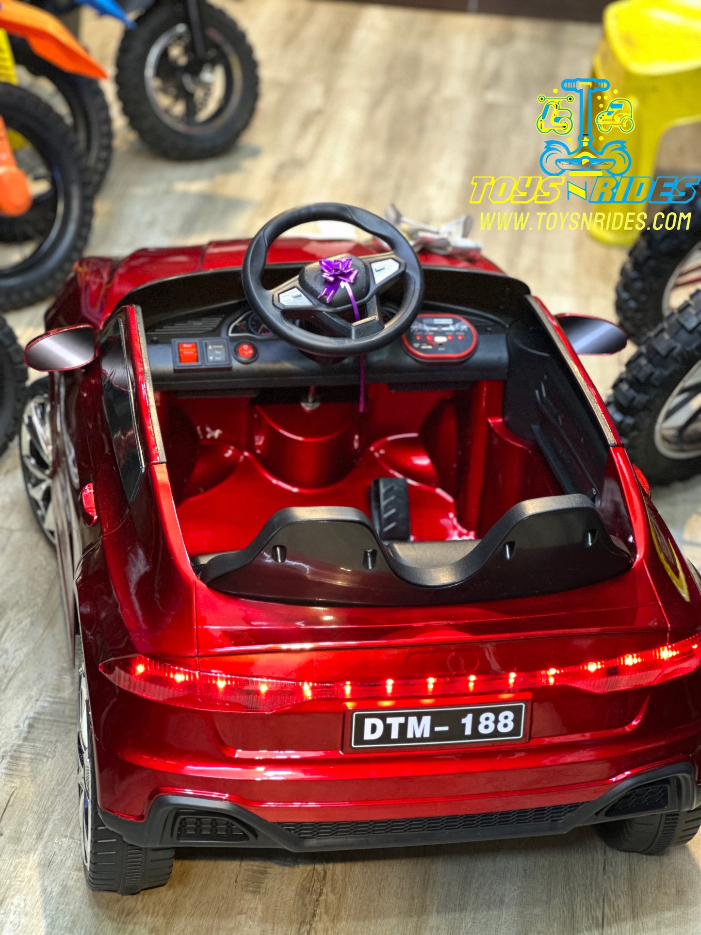 Happy toddler driving TOYSNRIDES Mercedes electric car outdoors