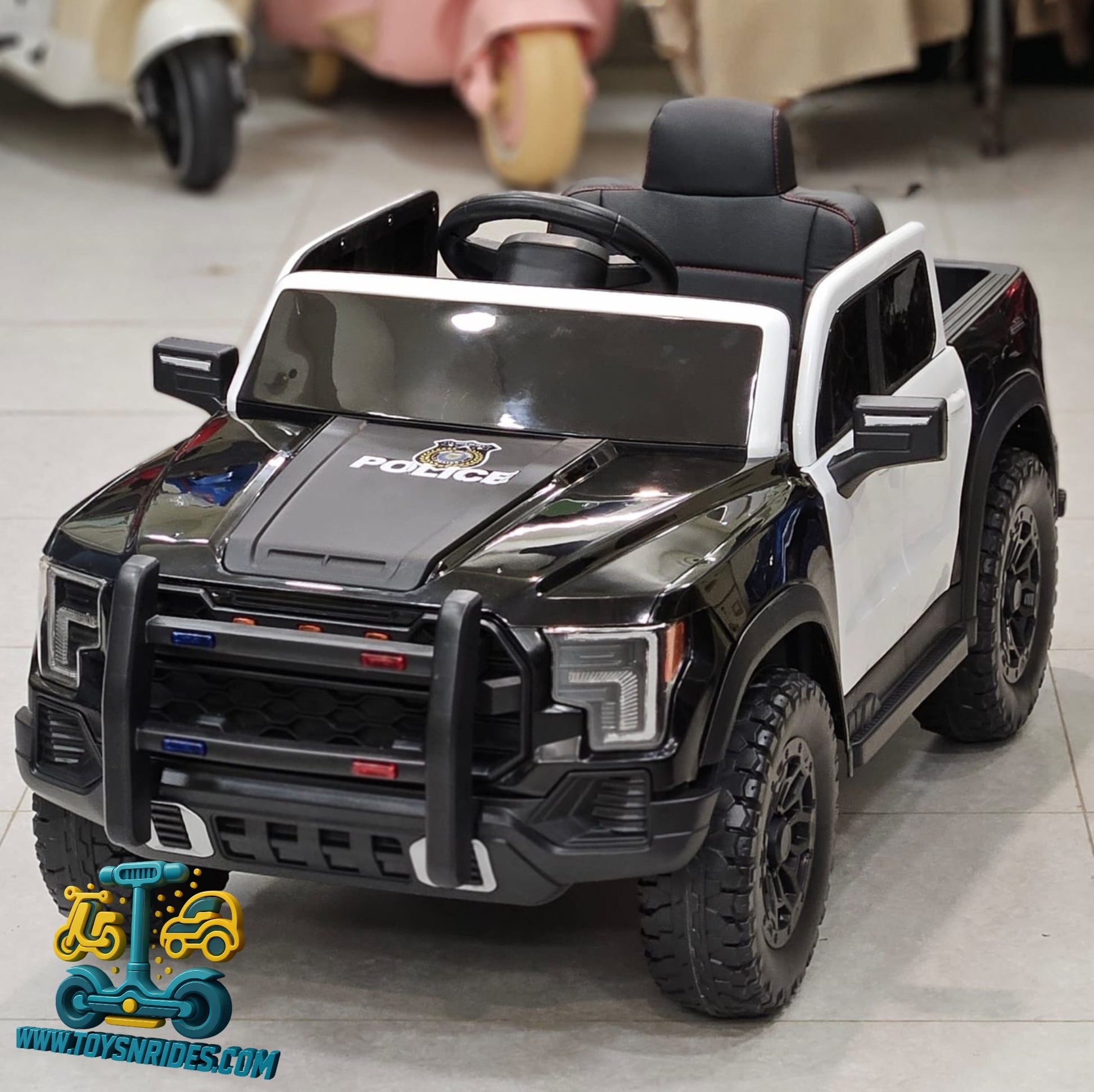 Black and white toy police car with detailed features on a gray floor.
