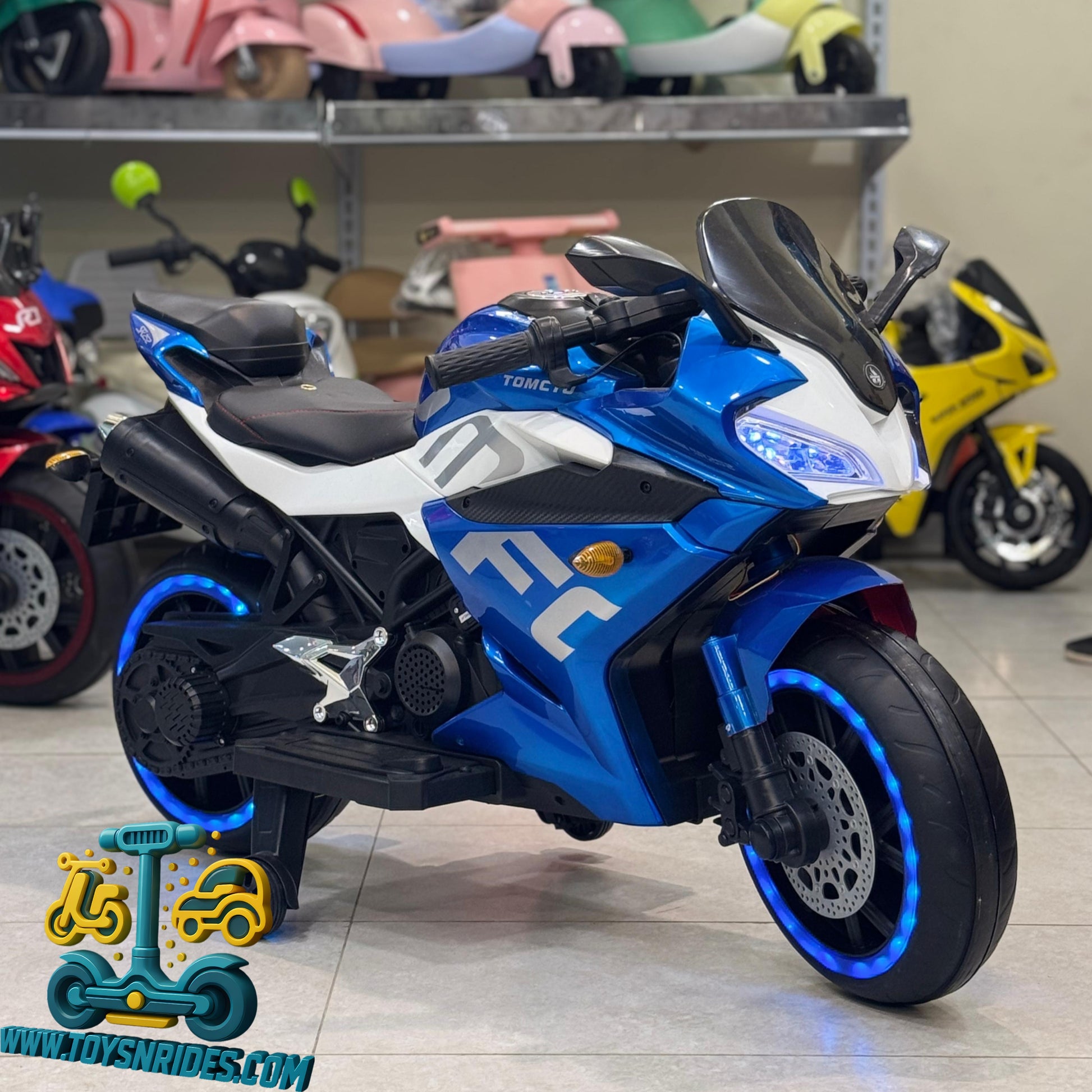 Blue toy motorcycle on a tiled floor, surrounded by other toys.