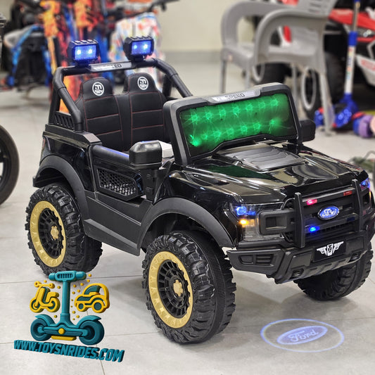 A black Ford-branded kids' ride-on toy SUV with gold-rimmed tires, blue LED light bars on the roof and front bumper, and a green illuminated display on the windshield, photographed in a showroom with other vehicles blurred in the background.