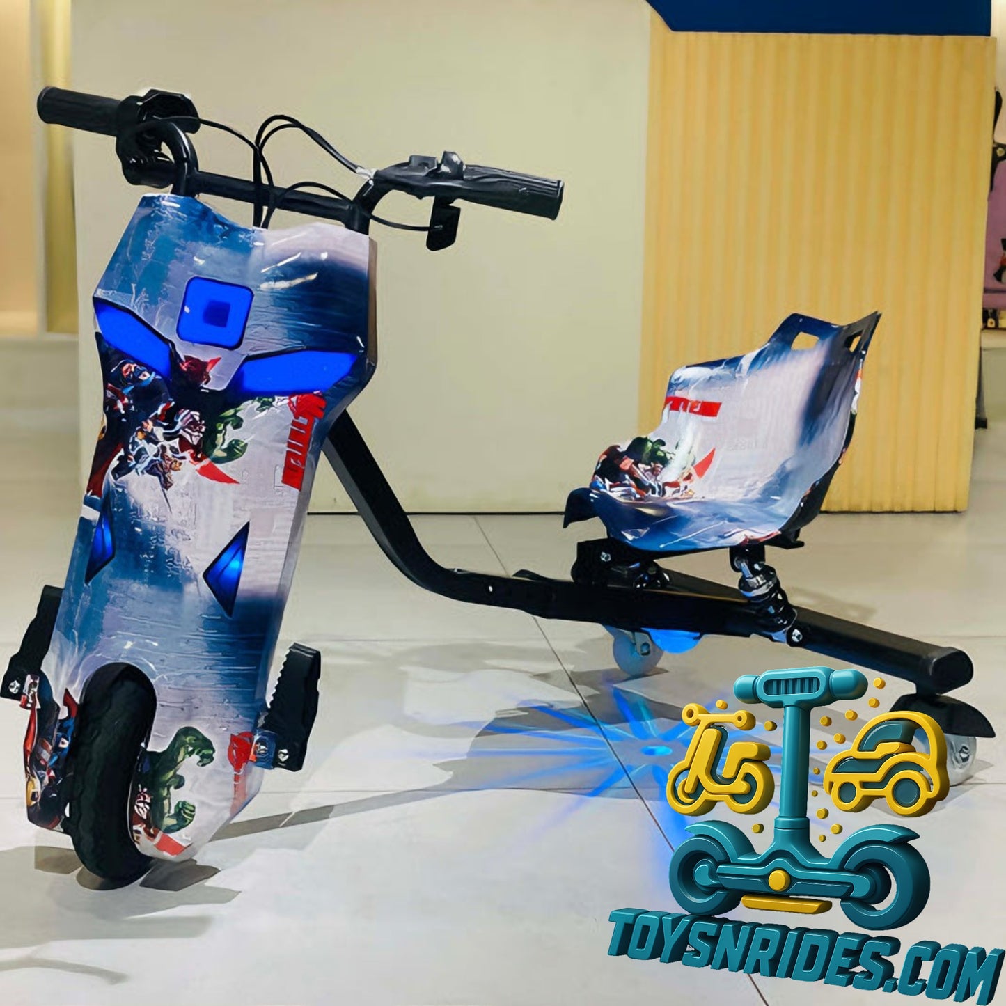 Children's scooter with colorful design on a reflective surface, brand 'TOYSNRIDES.COM' visible.