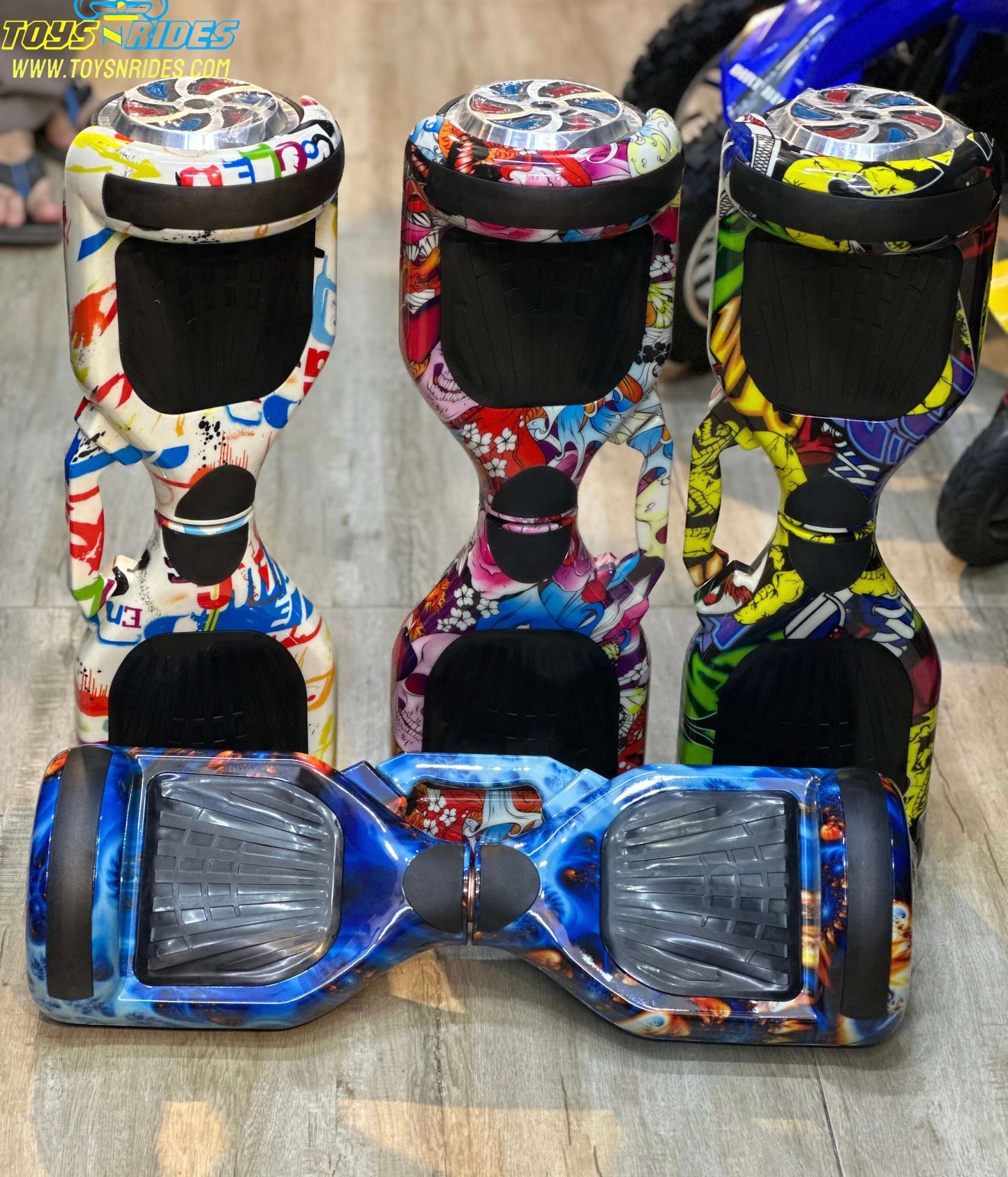 Colorful hoverboards on a wooden floor with 'ToysRUs' branding.