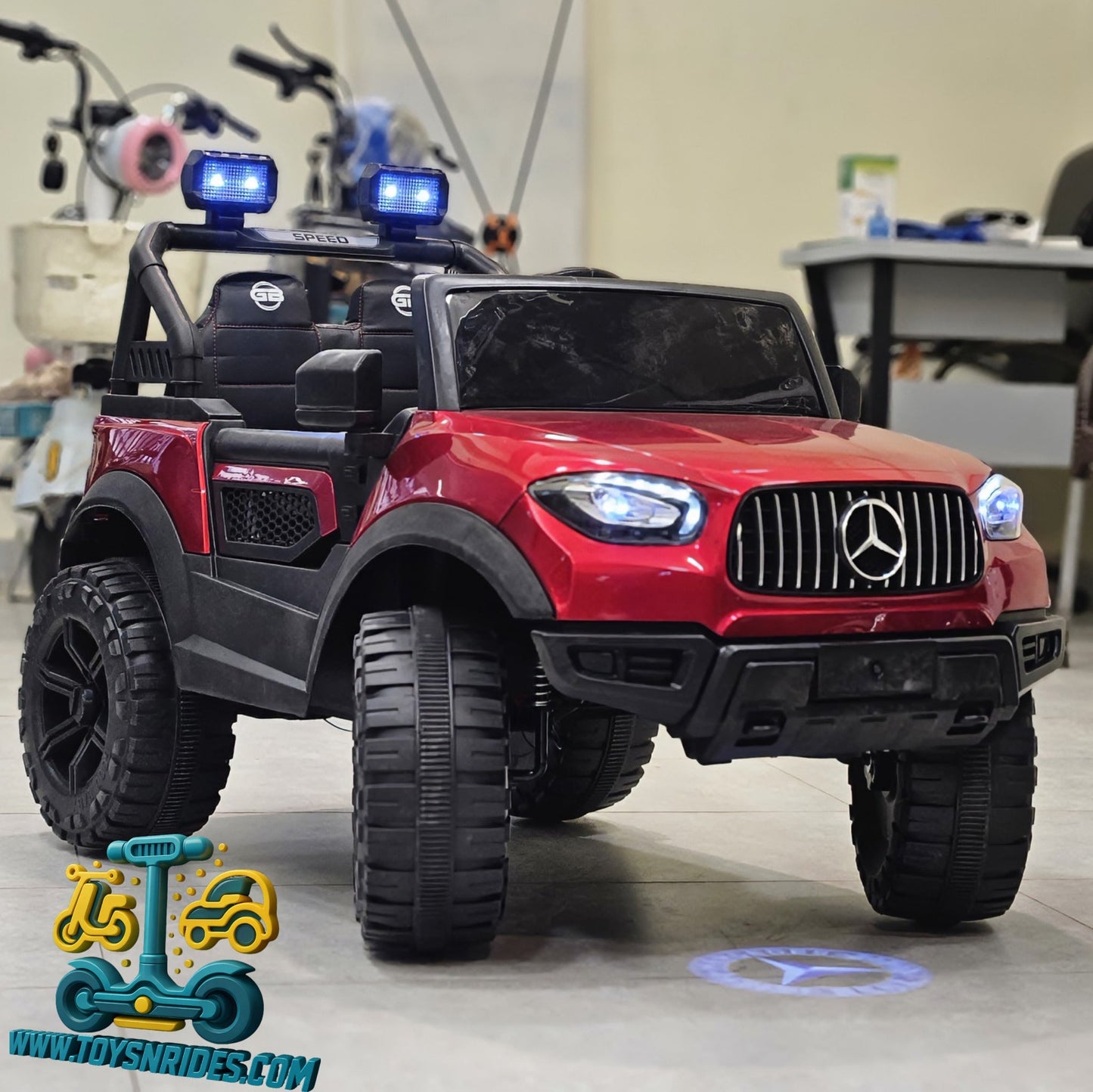 Red toy Mercedes-Benz truck with police lights in a room setting.