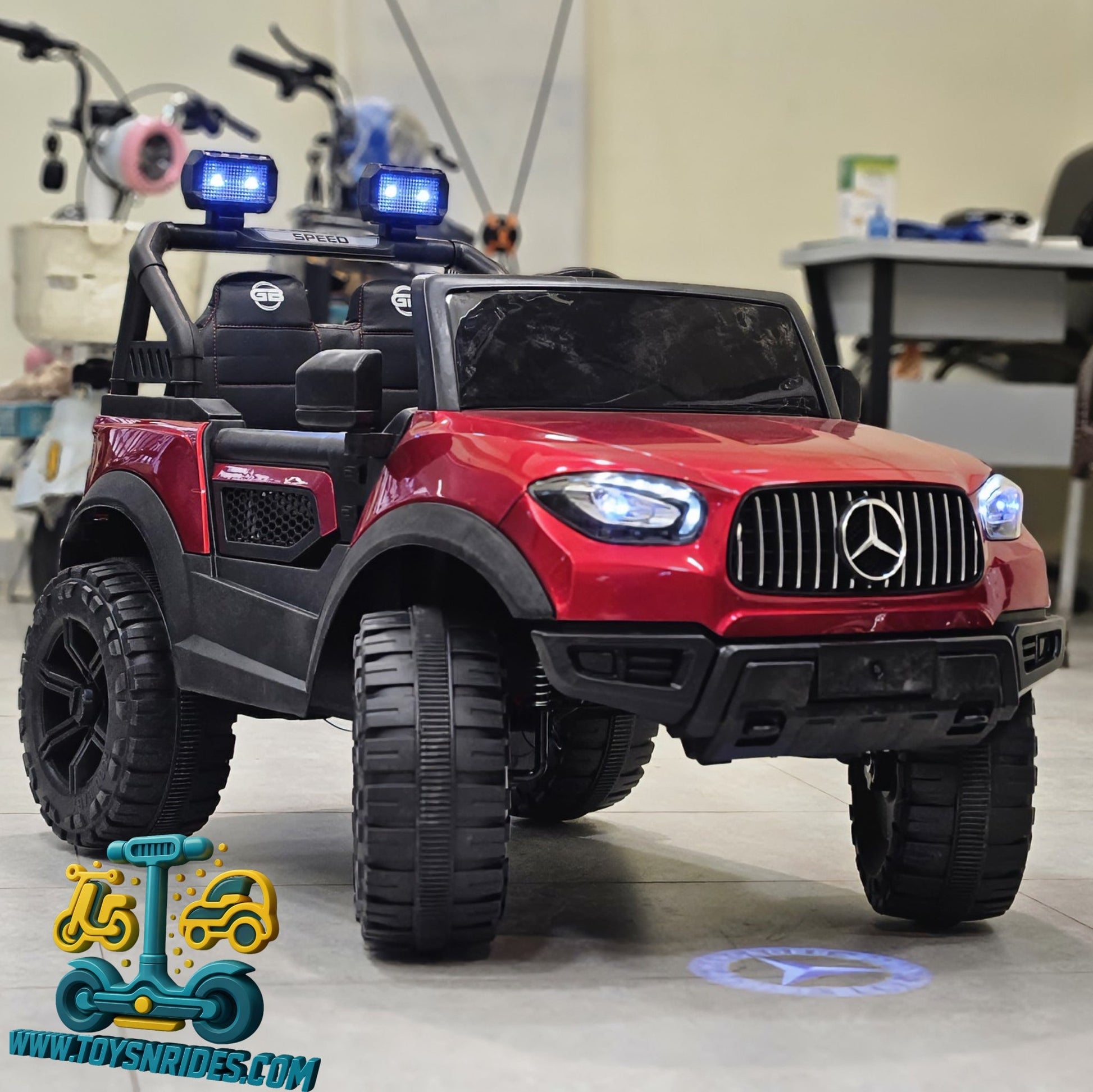 Red toy Mercedes-Benz truck with police lights in a room setting.