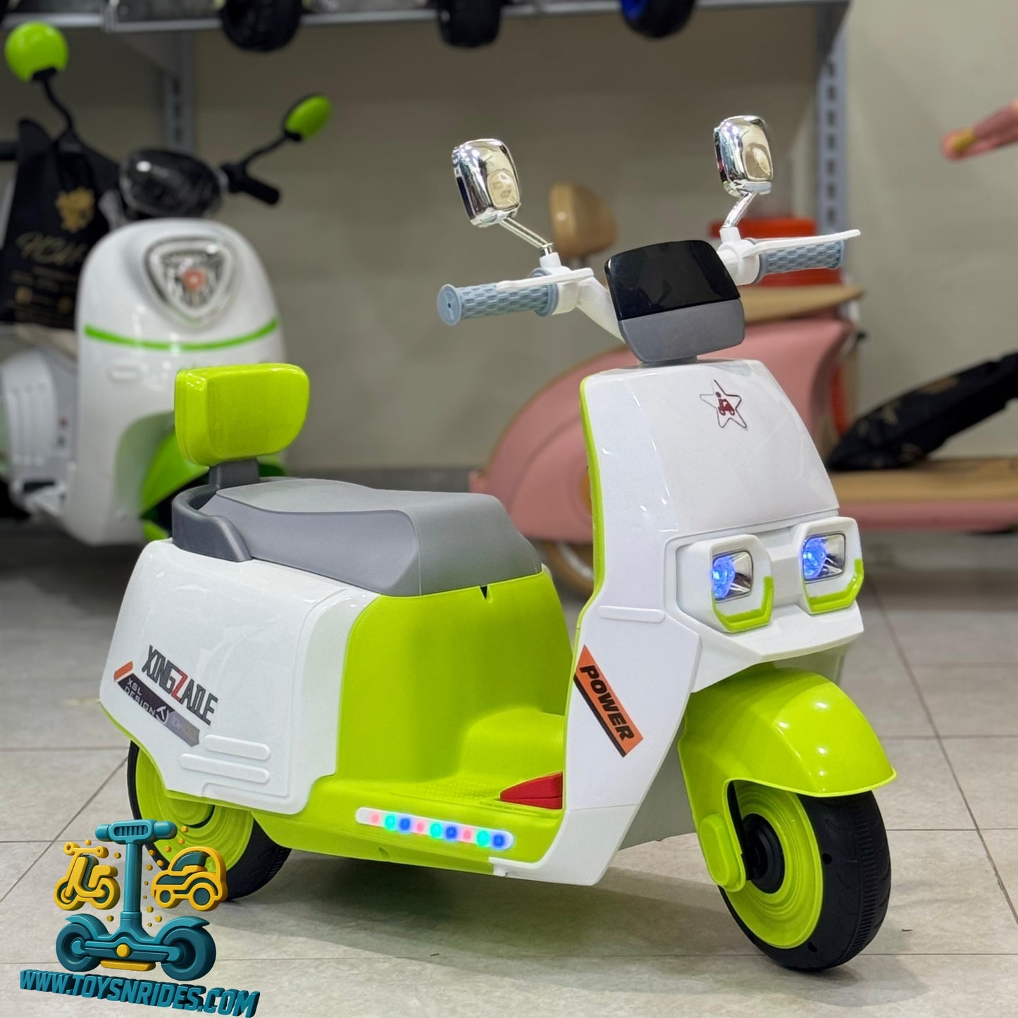 Green and white toy scooter with colorful lights on a blurred background