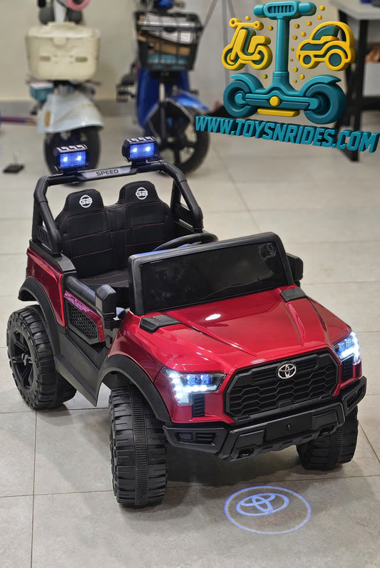 Red toy SUV with black seats on a tiled floor, branded 'ToySnrides.com'.