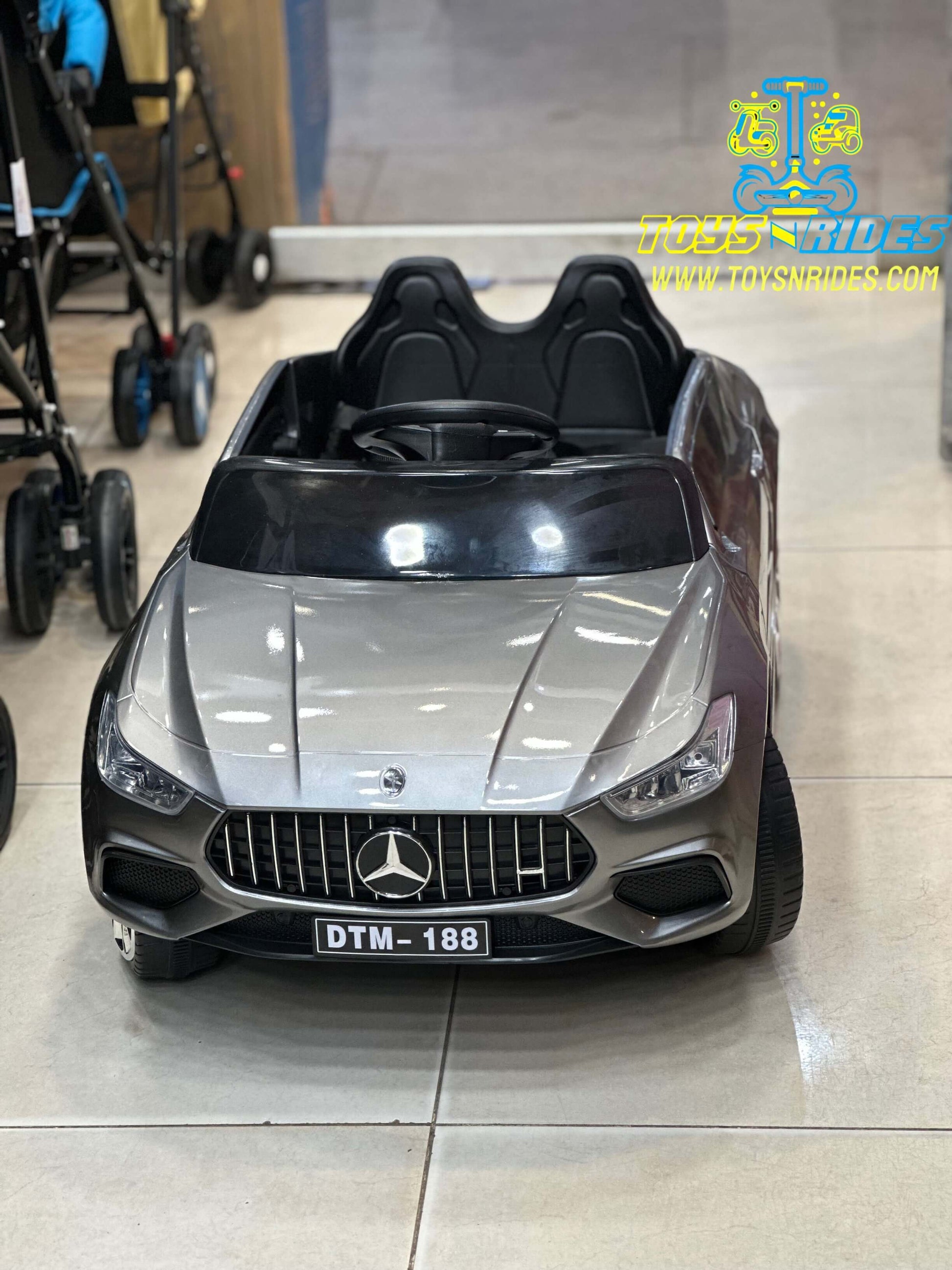 Happy toddler driving TOYSNRIDES Mercedes electric car outdoors